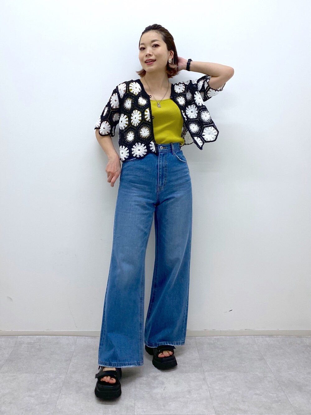 ブラック系のサンダル、イエロー系のタンクトップ、ブルー系のパンツを着用したレディースの夏コーディネートの5枚目の写真