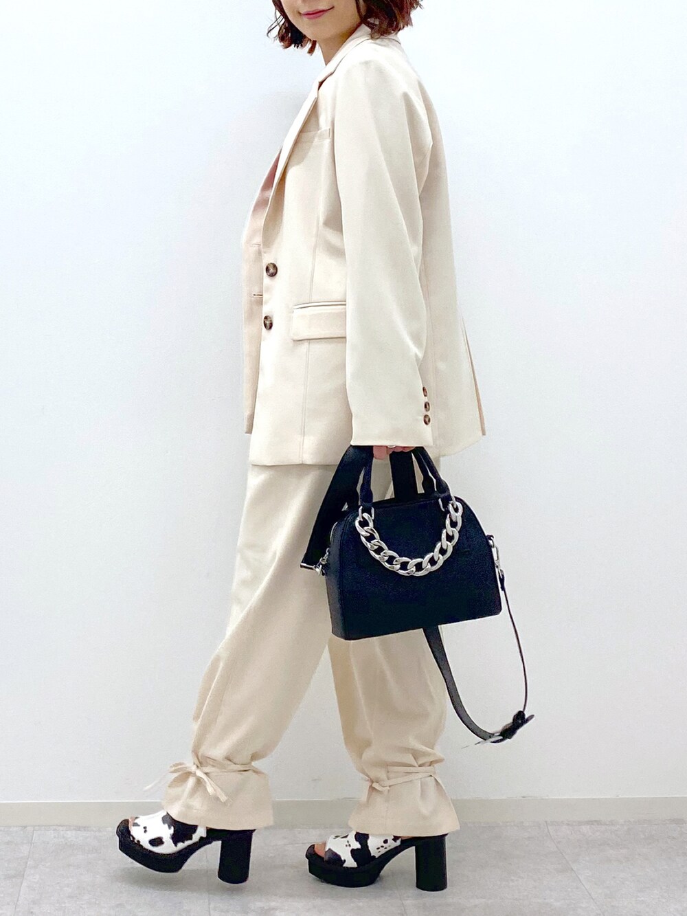 レッド系のタンクトップ、ホワイト系のその他パンツ、ブラック系のショルダーバッグを着用したレディースの春コーディネートの5枚目の写真