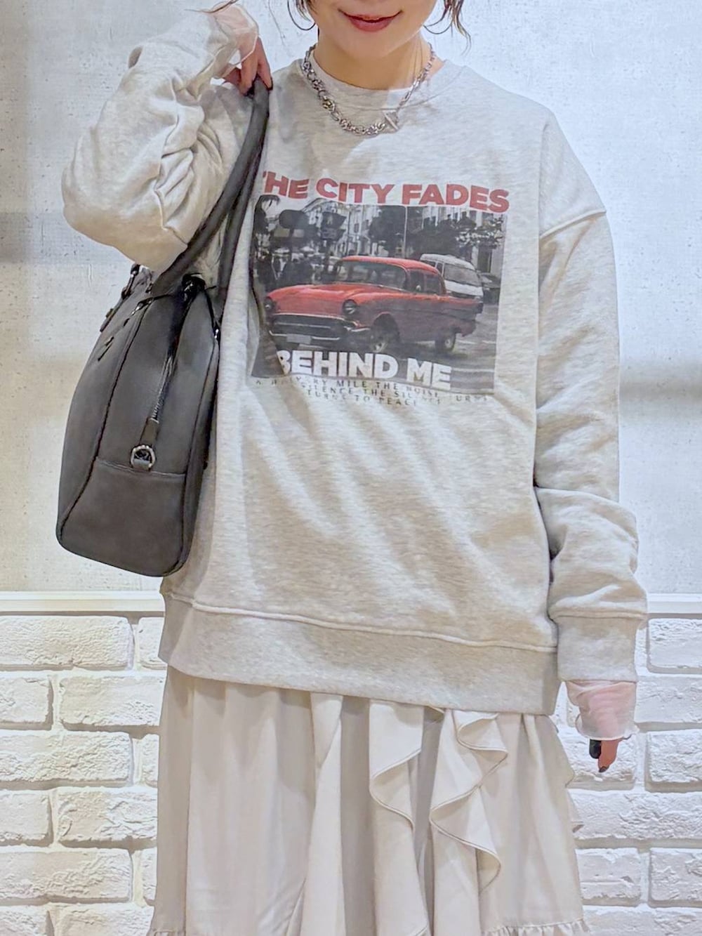 ホワイト系のスニーカー、グレー系のボストンバッグ、ベージュ系のスカートを着用したレディースの冬コーディネートの3枚目の写真