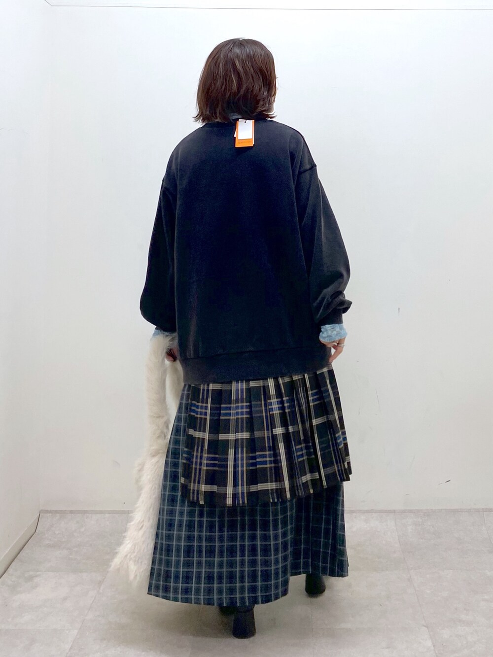 グレー系のスウェット、ブルー系のスカート、ホワイト系のショルダーバッグを着用したレディースの秋コーディネートの6枚目の写真