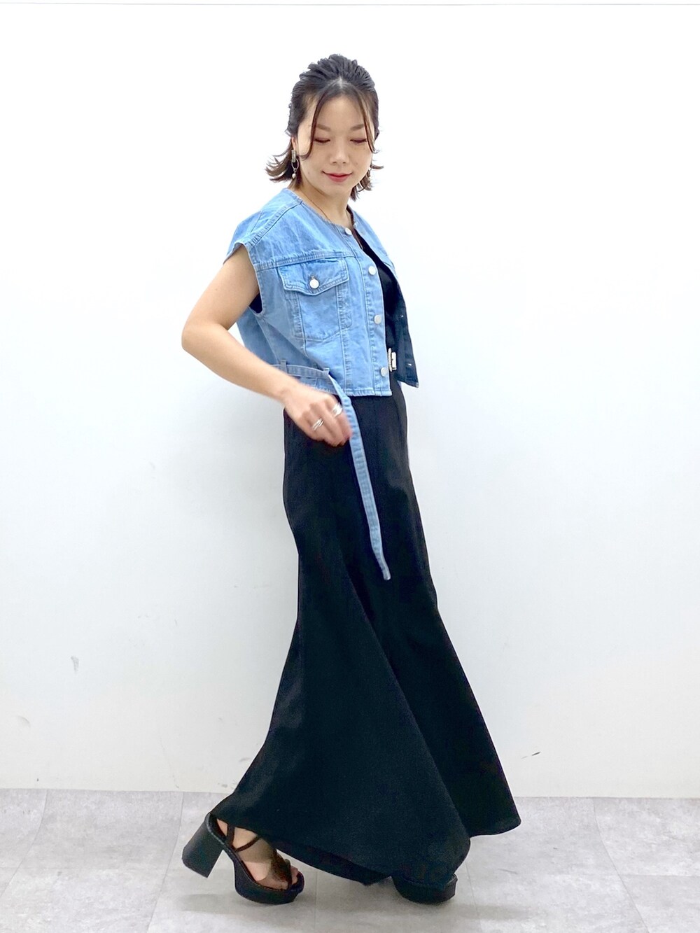 ブラック系のスカート、ブルー系のその他アウター、その他のサンダルを着用したレディースの春コーディネートの3枚目の写真