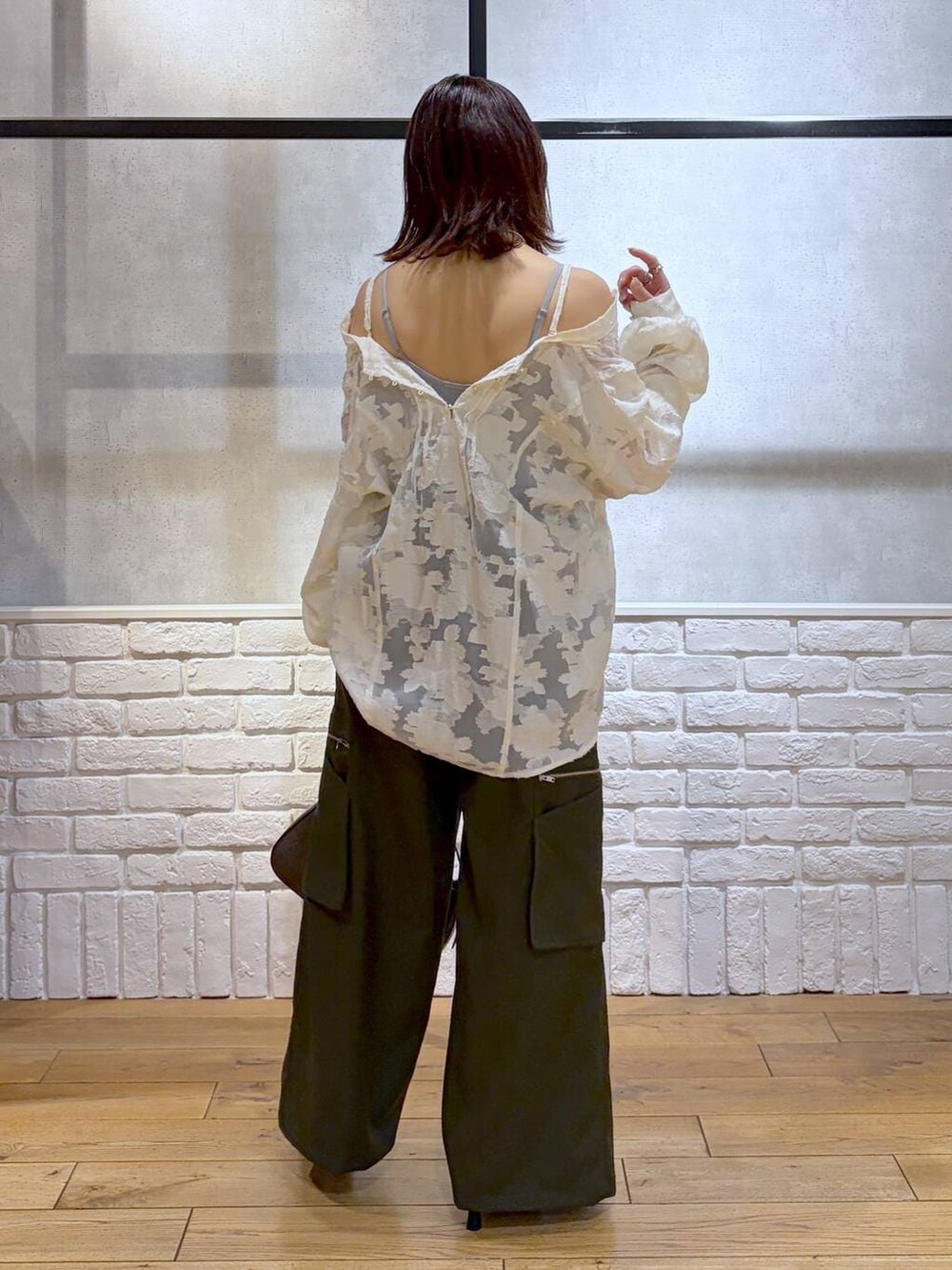 ブラウン系のハンドバッグ、グリーン系のスラックス、ホワイト系のTシャツ/カットソーを着用したレディースの冬コーディネートの8枚目の写真