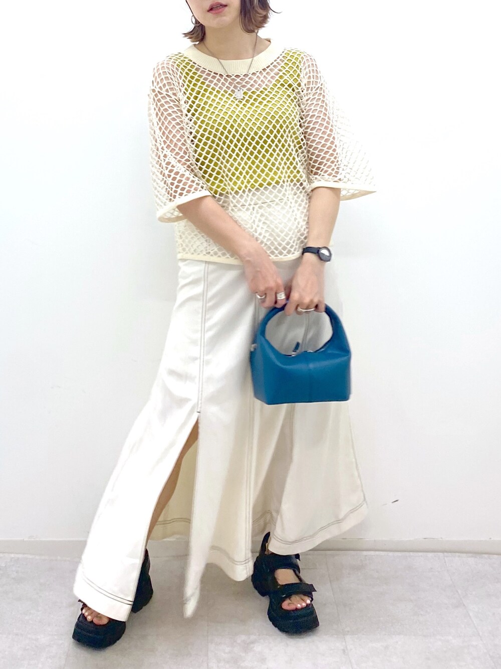 ホワイト系のスカート、ブラック系のサンダル、ブルー系のショルダーバッグを着用したレディースの夏コーディネートの4枚目の写真