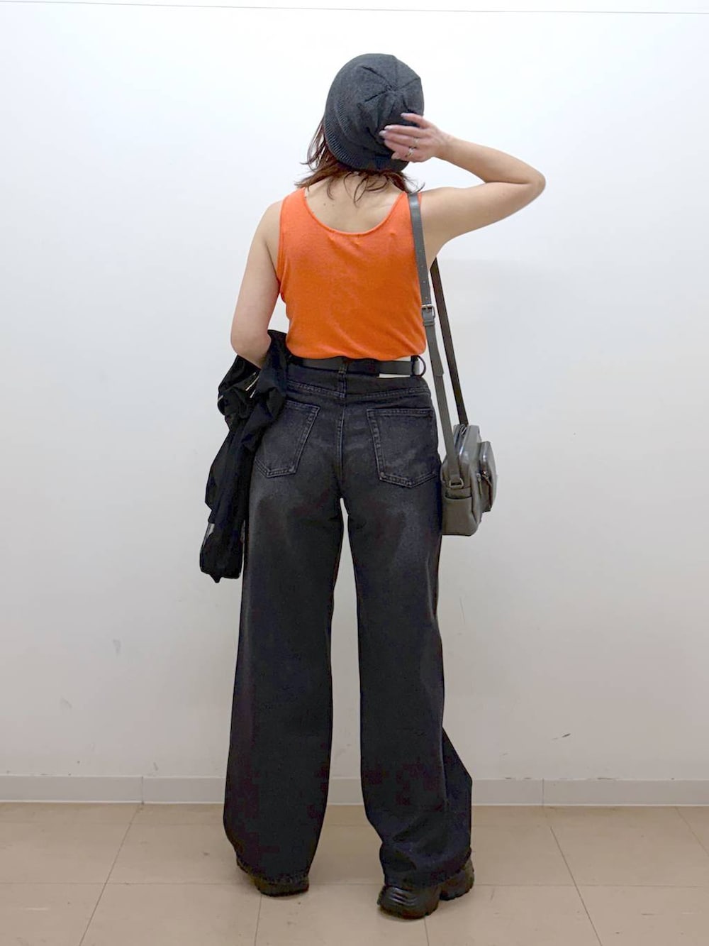 ホワイト系のキャミソール、ブラック系のデニムパンツ、ブラック系のブルゾンを着用したレディースの春コーディネートの5枚目の写真