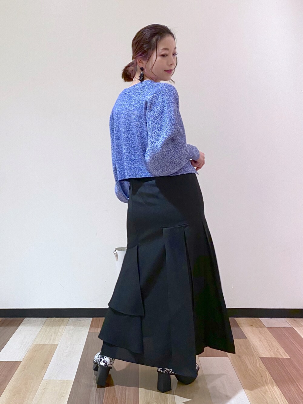 ブラック系のスカート、ホワイト系のブーツ、ホワイト系のショルダーバッグを着用したレディースの冬コーディネートの3枚目の写真