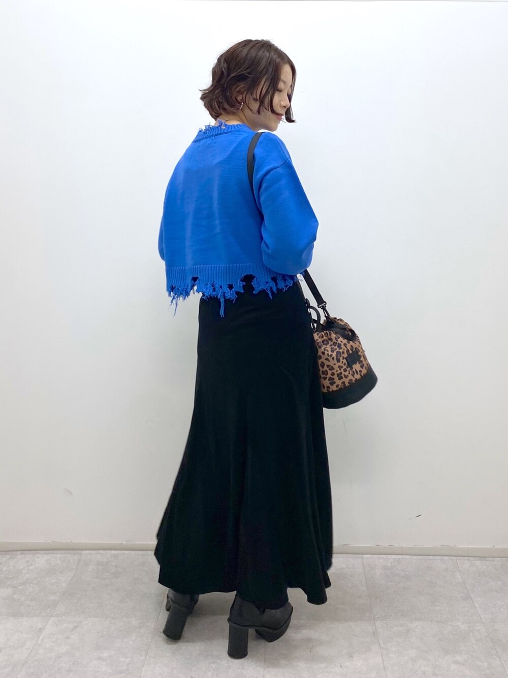 ブルー系のニット/セーター、ブラック系のスカート、その他のショルダーバッグを着用したレディースの秋コーディネートの3枚目の写真