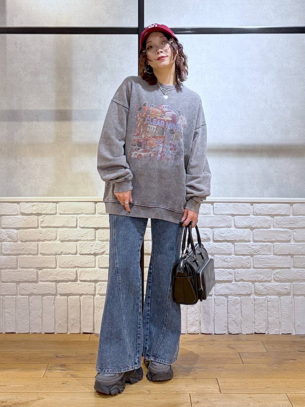 グレー系のスニーカー、ブルー系のデニムパンツ、ブラック系のショルダーバッグを着用したレディースの冬コーディネートの4枚目の写真