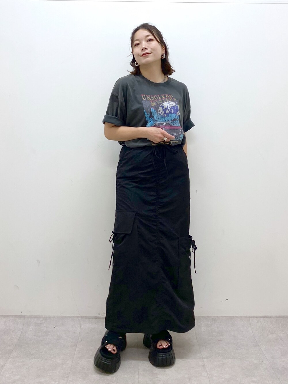 グレー系のTシャツ/カットソー、ブラック系のスカート、ブラック系のスニーカーを着用したレディースの夏コーディネートの4枚目の写真