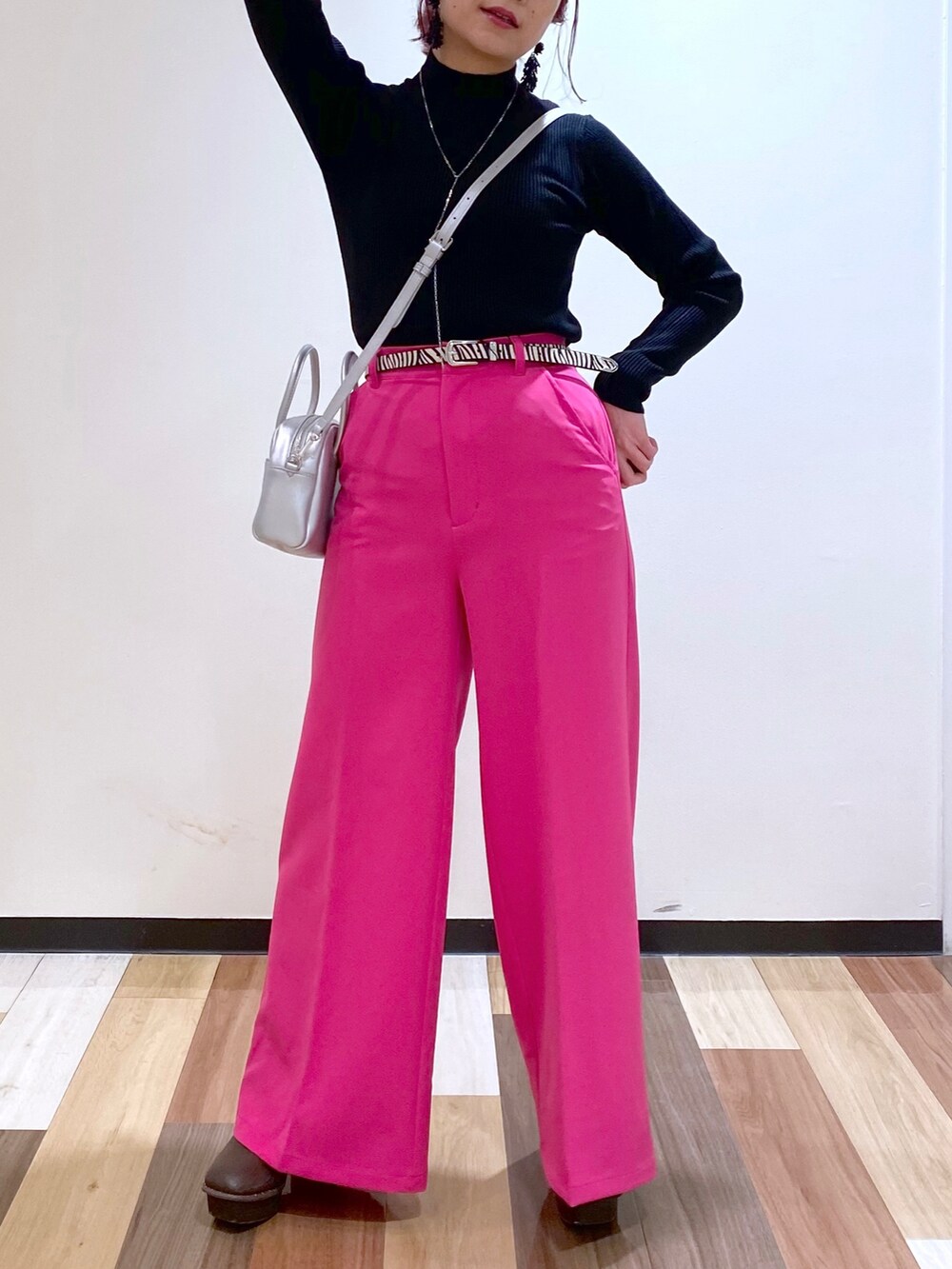 ブラック系のニット/セーター、シルバー系のボストンバッグ、ピンク系のスラックスを着用したレディースの冬コーディネートの2枚目の写真