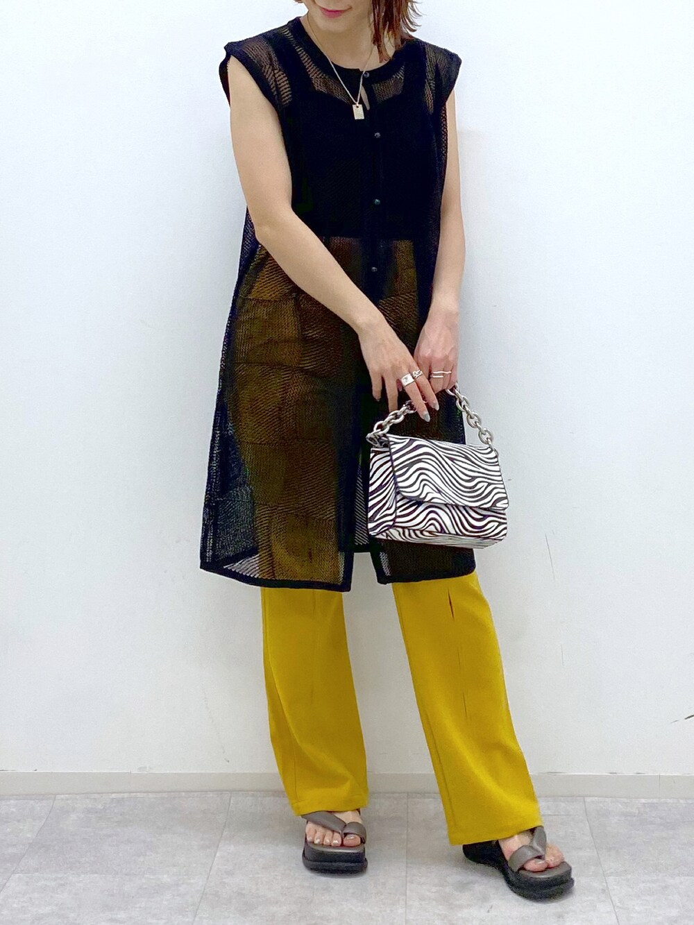 ブラック系のカーディガン/ボレロ、ブラック系のタンクトップ、その他のショルダーバッグを着用したレディースの春コーディネートの5枚目の写真