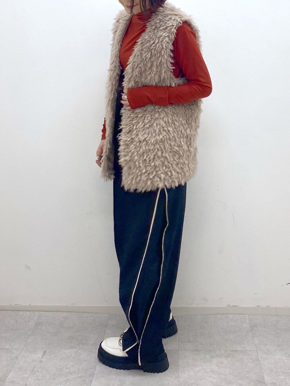 ベージュ系のその他アウター、オレンジ系のTシャツ/カットソー、ホワイト系のシューズを着用したレディースの秋コーディネートの4枚目の写真