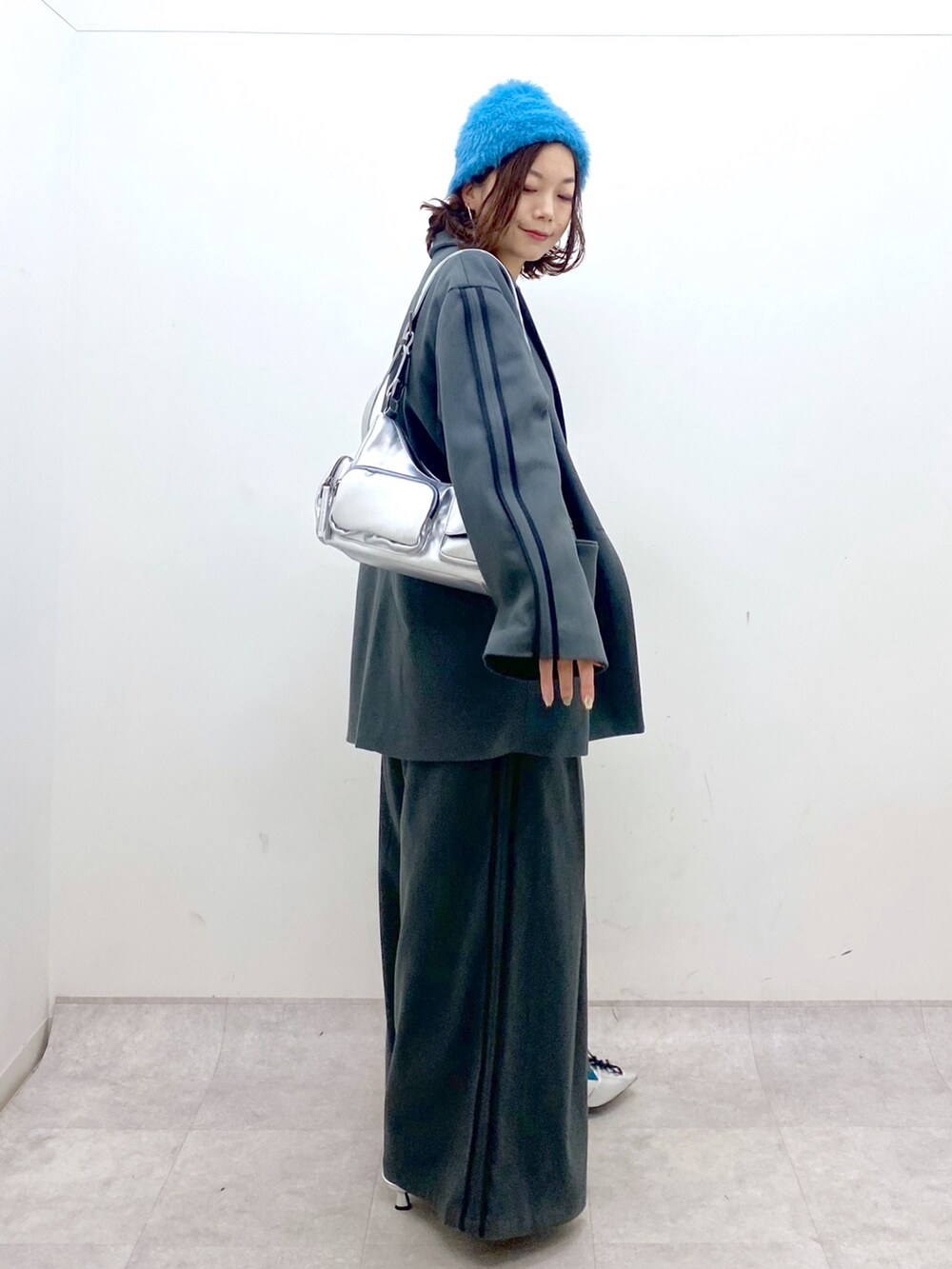 グレー系のスラックス、シルバー系のパンプス、シルバー系のショルダーバッグを着用したレディースの秋コーディネートの6枚目の写真