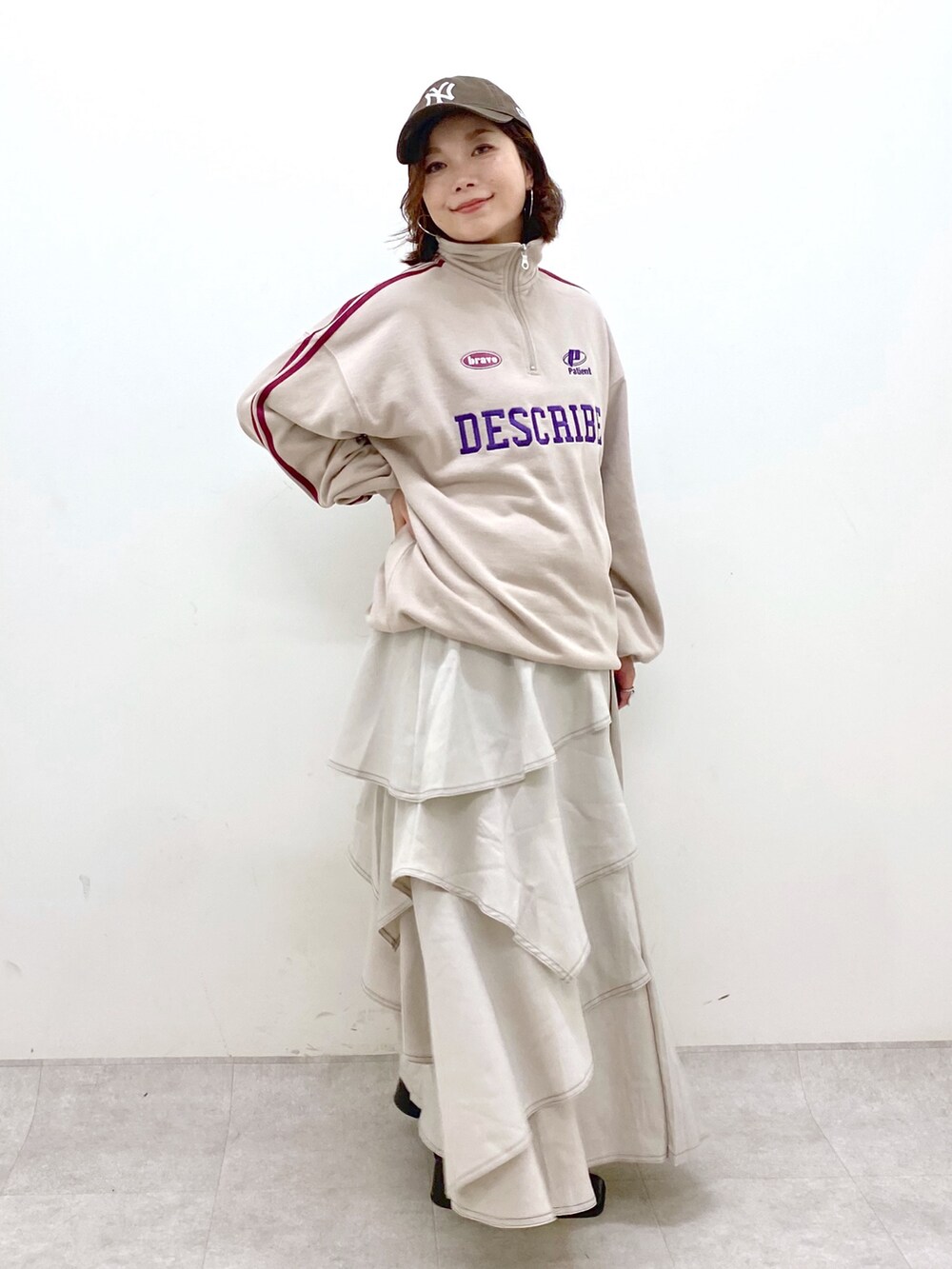 ベージュ系のスウェット、グレー系のスカート、ブラック系のブーツを着用したレディースの秋コーディネートの8枚目の写真