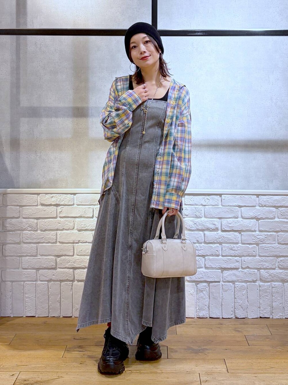 ブラック系のスニーカー、ホワイト系のボストンバッグ、ブラック系のワンピースを着用したレディースの春コーディネートの9枚目の写真