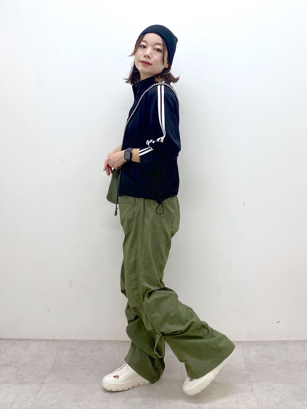 グリーン系のカーゴパンツ、ホワイト系のスニーカー、グリーン系のショルダーバッグを着用したレディースの夏コーディネートの5枚目の写真