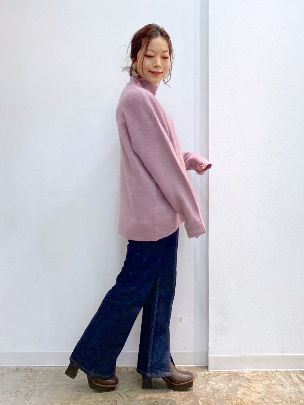 ピンク系のニット/セーター、ブルー系のデニムパンツ、ブラウン系のブーツを着用したレディースの秋コーディネートの3枚目の写真