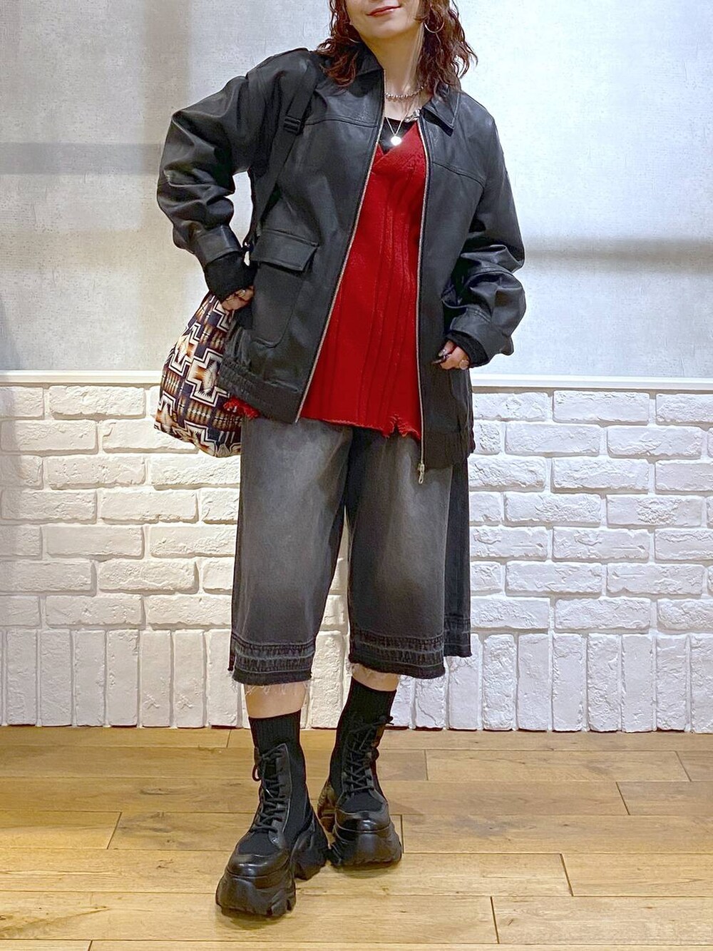 ブラック系のブーツ、ブラック系のデニムパンツ、ブラック系のブルゾンを着用したレディースの秋コーディネートの2枚目の写真