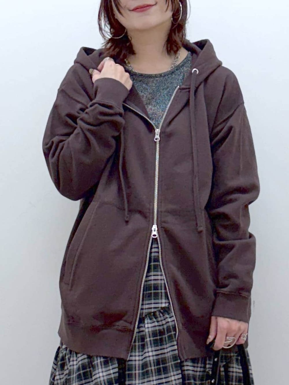 ブラック系のブーツ、シルバー系のTシャツ/カットソー、ブラウン系のパーカーを着用したレディースの冬コーディネートの2枚目の写真