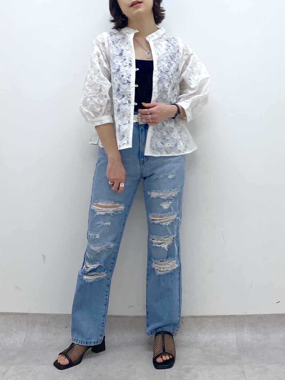 ブルー系のパンツ、ホワイト系のシャツ/ブラウス、ブラック系のトップスを着用したレディースの春コーディネートの4枚目の写真