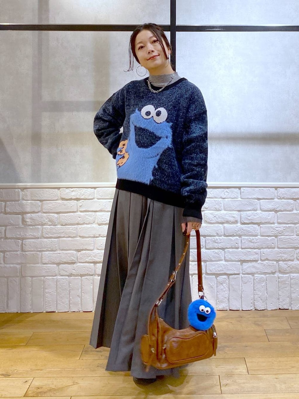 ブラック系のローファー、グレー系のスカート、ブラウン系のショルダーバッグを着用したレディースの冬コーディネートの9枚目の写真