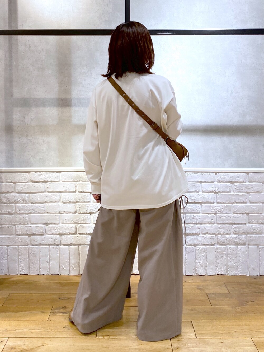 ブラウン系のスラックス、ベージュ系のショルダーバッグ、ブラウン系のパンプスを着用したレディースの春コーディネートの5枚目の写真