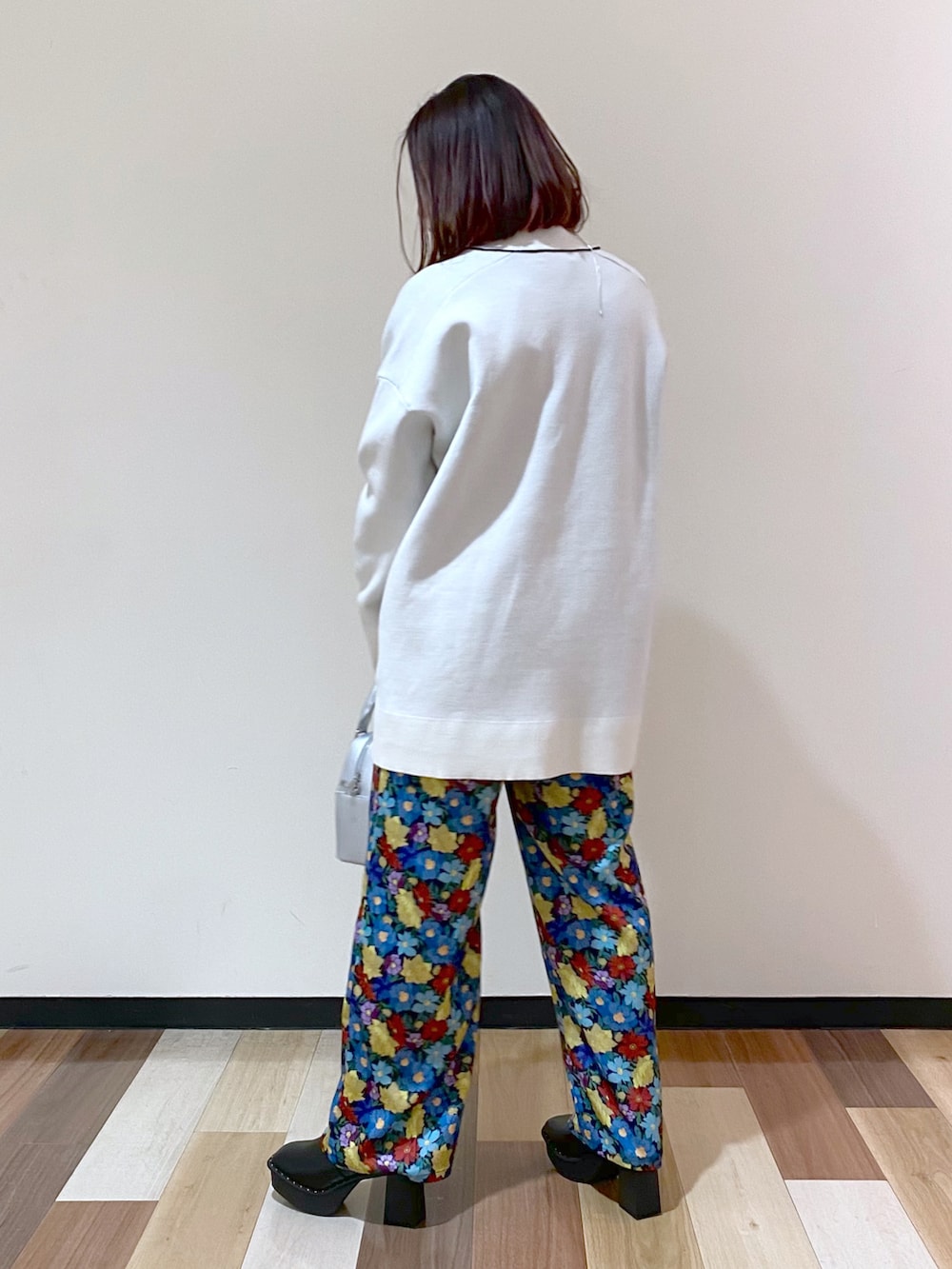 ブラック系のブーツ、シルバー系のショルダーバッグ、ホワイト系のカーディガン/ボレロを着用したレディースの冬コーディネートの4枚目の写真