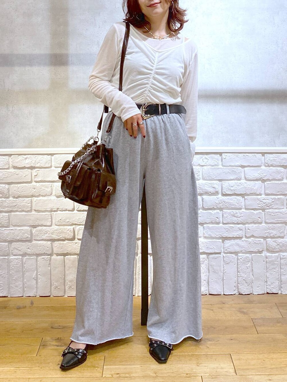 ブラック系のパンプス、グレー系のスウェットパンツ、ブラック系のハンドバッグを着用したレディースの秋コーディネートの3枚目の写真