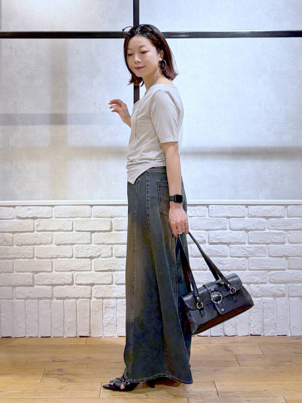グリーン系のデニムパンツ、ブラック系のサンダル、ベージュ系のTシャツ/カットソーを着用したレディースの夏コーディネートの7枚目の写真