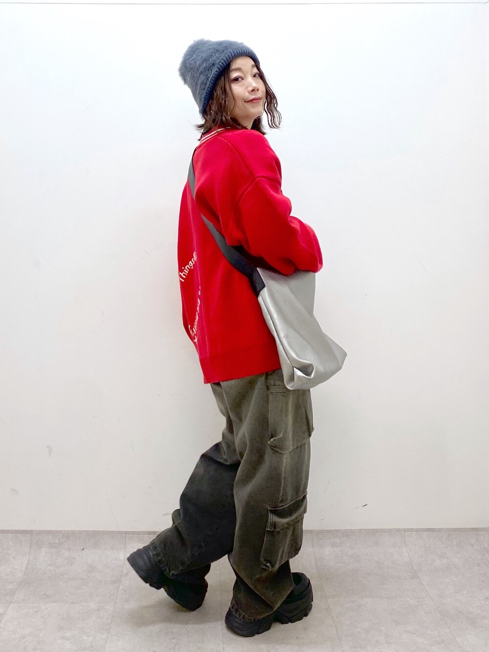 ブラック系のデニムパンツ、ブラック系のブーツ、シルバー系のトートバッグを着用したレディースの秋コーディネートの8枚目の写真