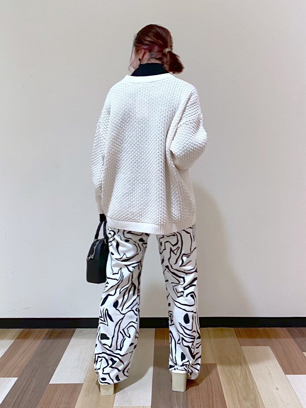 ホワイト系のその他パンツ、ホワイト系のサンダル、ブラック系のショルダーバッグを着用したレディースの冬コーディネートの4枚目の写真