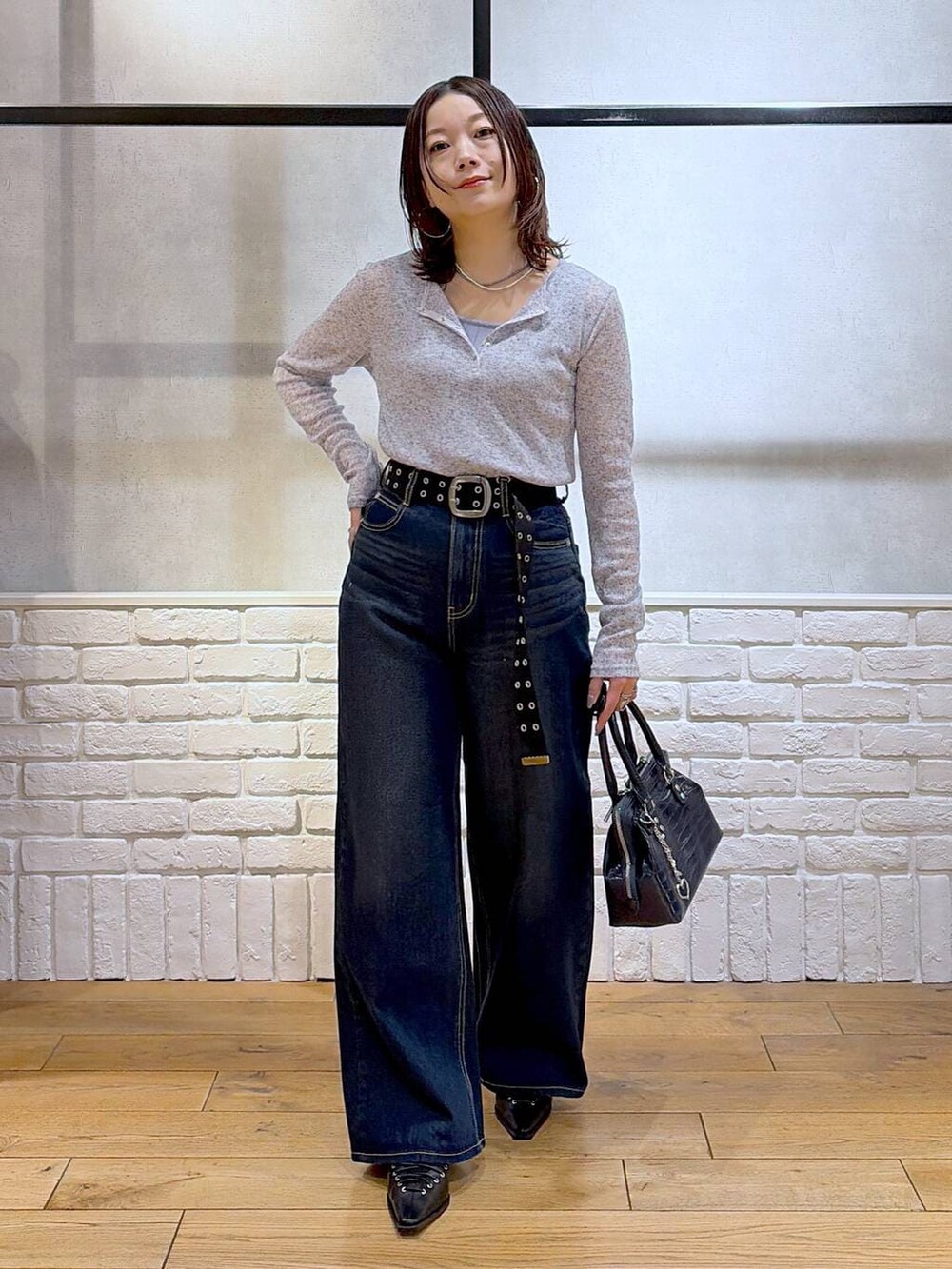 ブルー系のスラックス、ブルー系のハンドバッグ、ブルー系のタンクトップを着用したレディースの春コーディネートの4枚目の写真