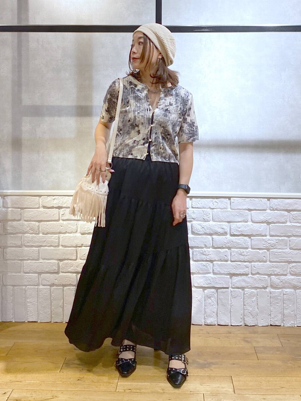 ブラック系のパンプス、ブラック系のスカート、ホワイト系のショルダーバッグを着用したレディースの夏コーディネートの4枚目の写真