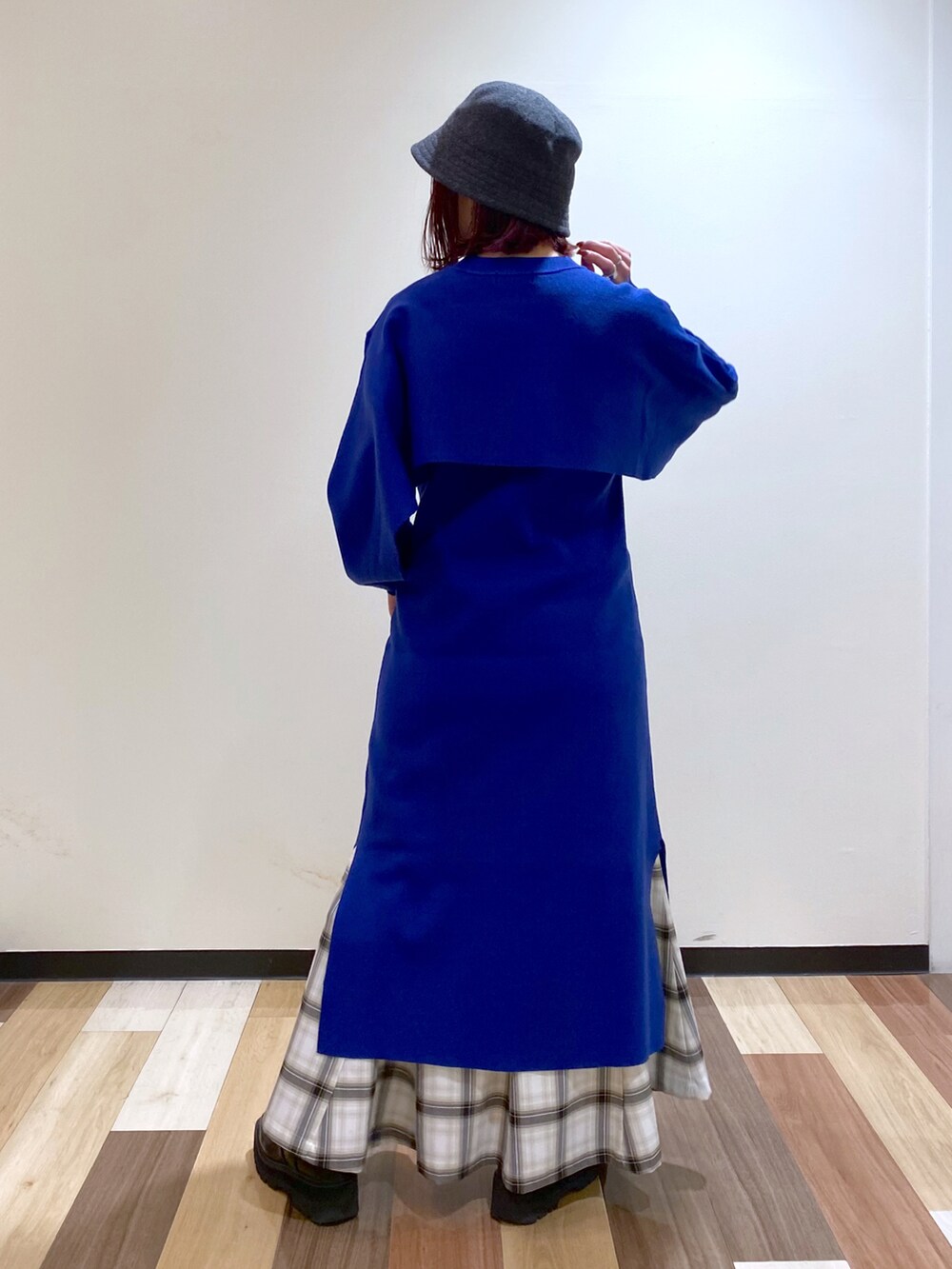 ブルー系のワンピース、ブラック系のブーツ、ホワイト系のスカートを着用したレディースの冬コーディネートの4枚目の写真