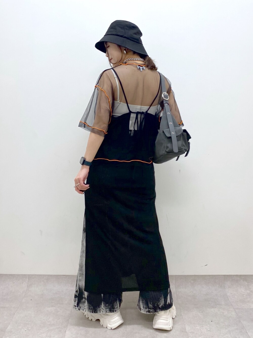 グレー系のショルダーバッグ、ホワイト系のスニーカー、ブラック系のデニムパンツを着用したレディースの春コーディネートの5枚目の写真