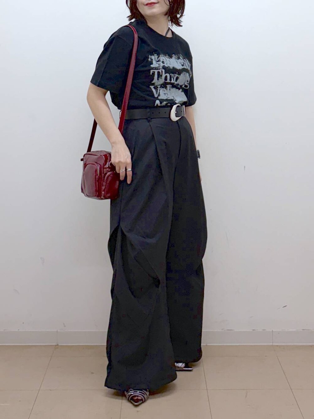 ブラック系のTシャツ/カットソー、レッド系のショルダーバッグ、その他のサンダルを着用したレディースの夏コーディネートの3枚目の写真