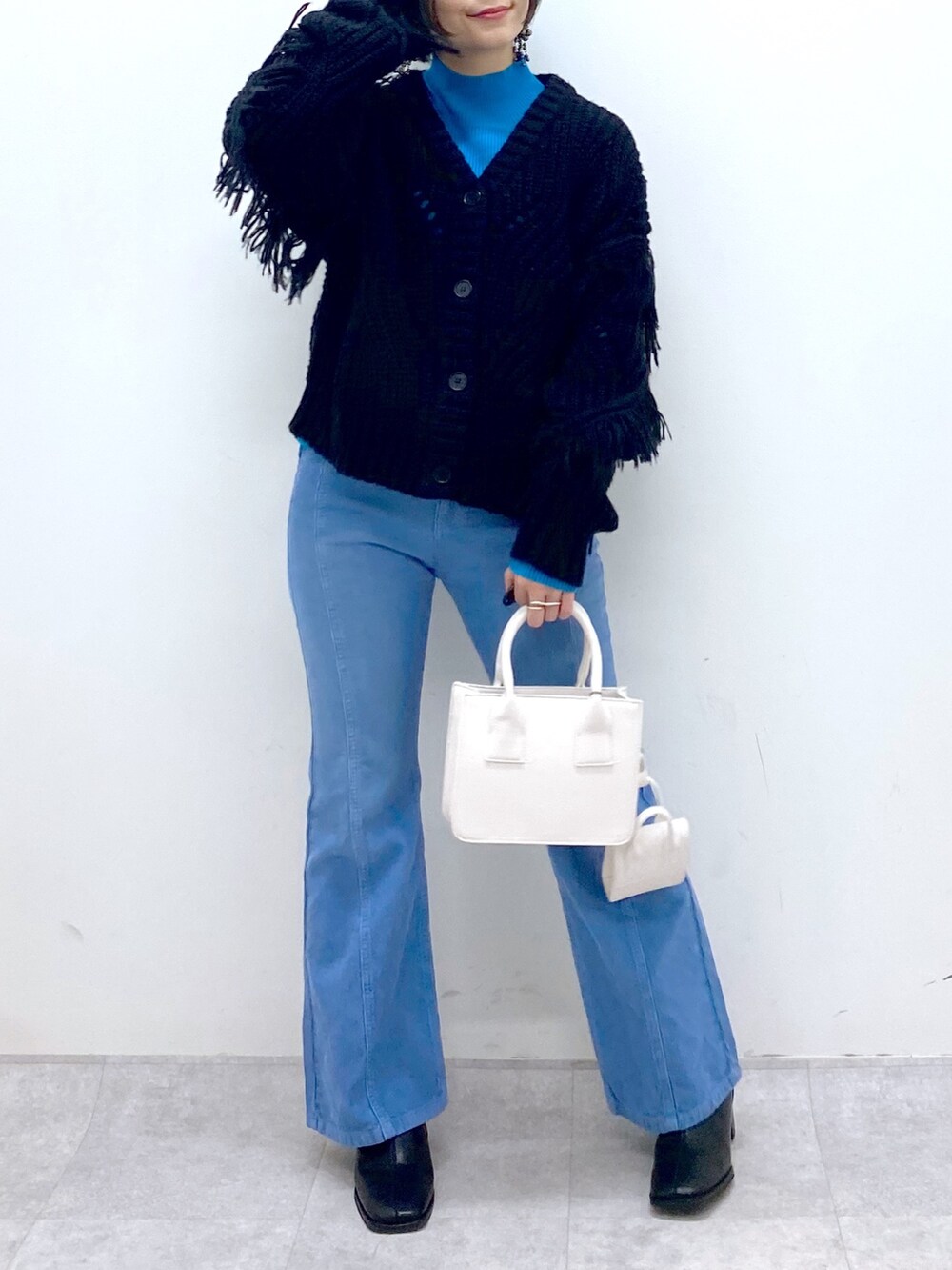 ブルー系のパンツ、ホワイト系のバッグ、ブラック系のシューズを着用したレディースの秋コーディネートの4枚目の写真