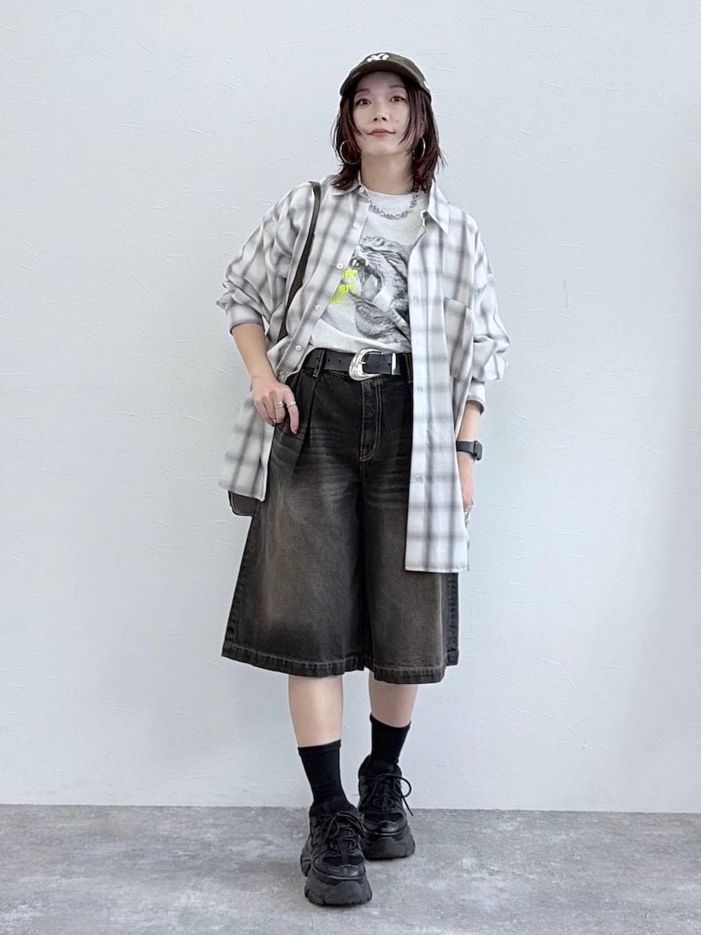 ブラック系のスニーカー、ブラウン系のショルダーバッグ、ホワイト系のシャツ/ブラウスを着用したレディースの春コーディネートの9枚目の写真