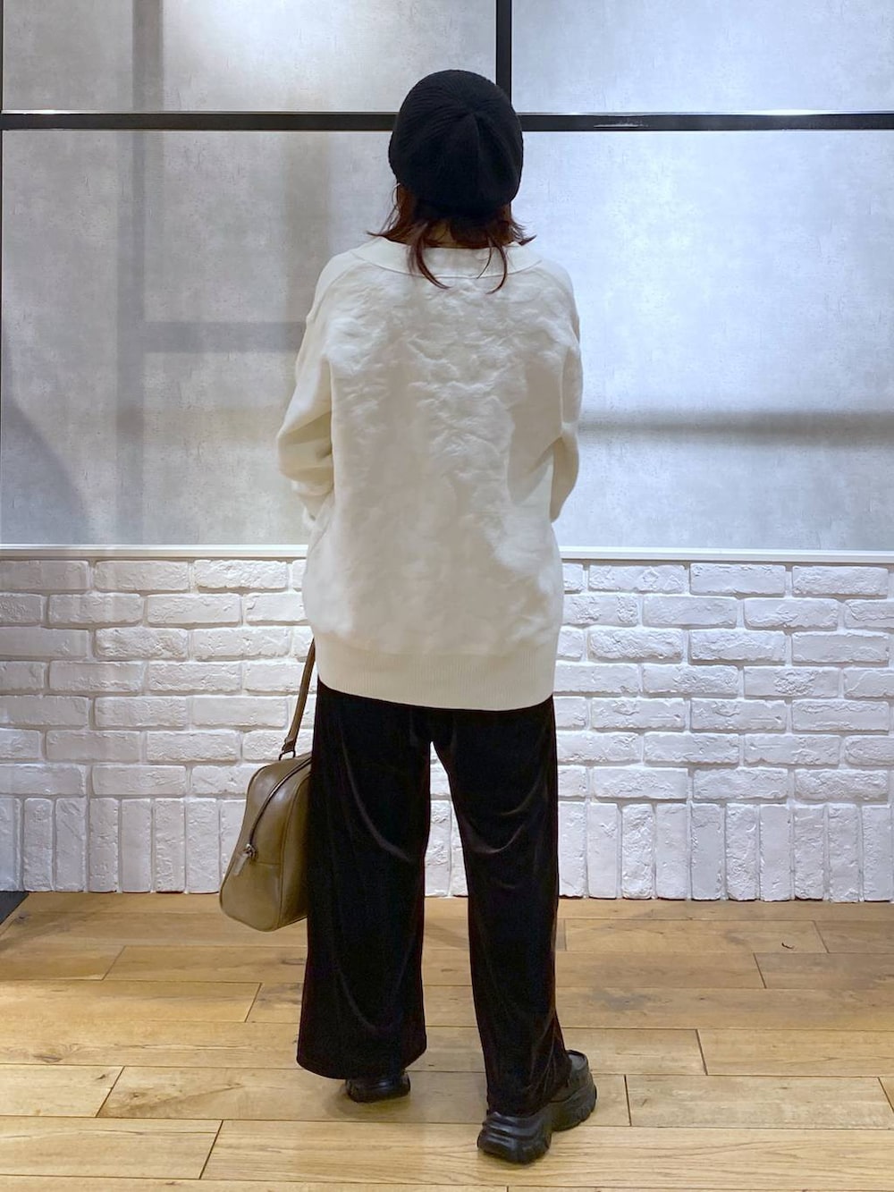 ベージュ系のボストンバッグ、イエロー系のTシャツ/カットソー、ブラック系のローファーを着用したレディースの冬コーディネートの6枚目の写真