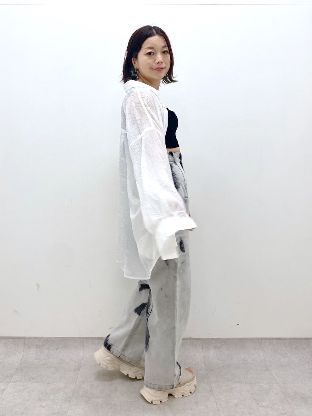 ホワイト系のサンダル、ブラック系のデニムパンツ、ブラック系のタンクトップを着用したレディースの夏コーディネートの3枚目の写真