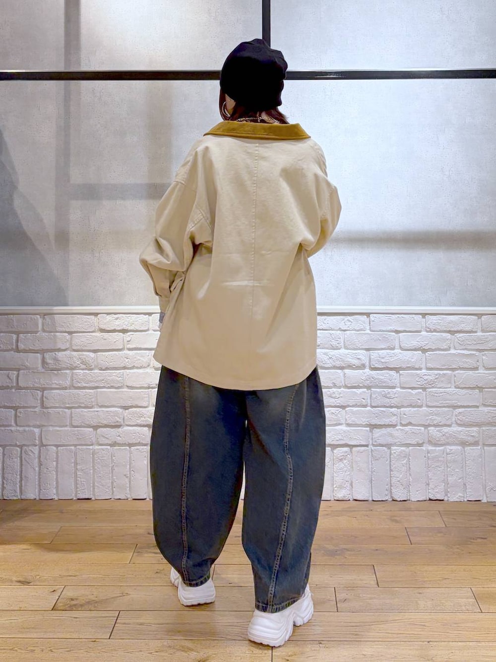 ホワイト系のスニーカー、ブラック系のボディバッグ/ウエストポーチ、ブルー系のデニムパンツを着用したレディースの冬コーディネートの6枚目の写真