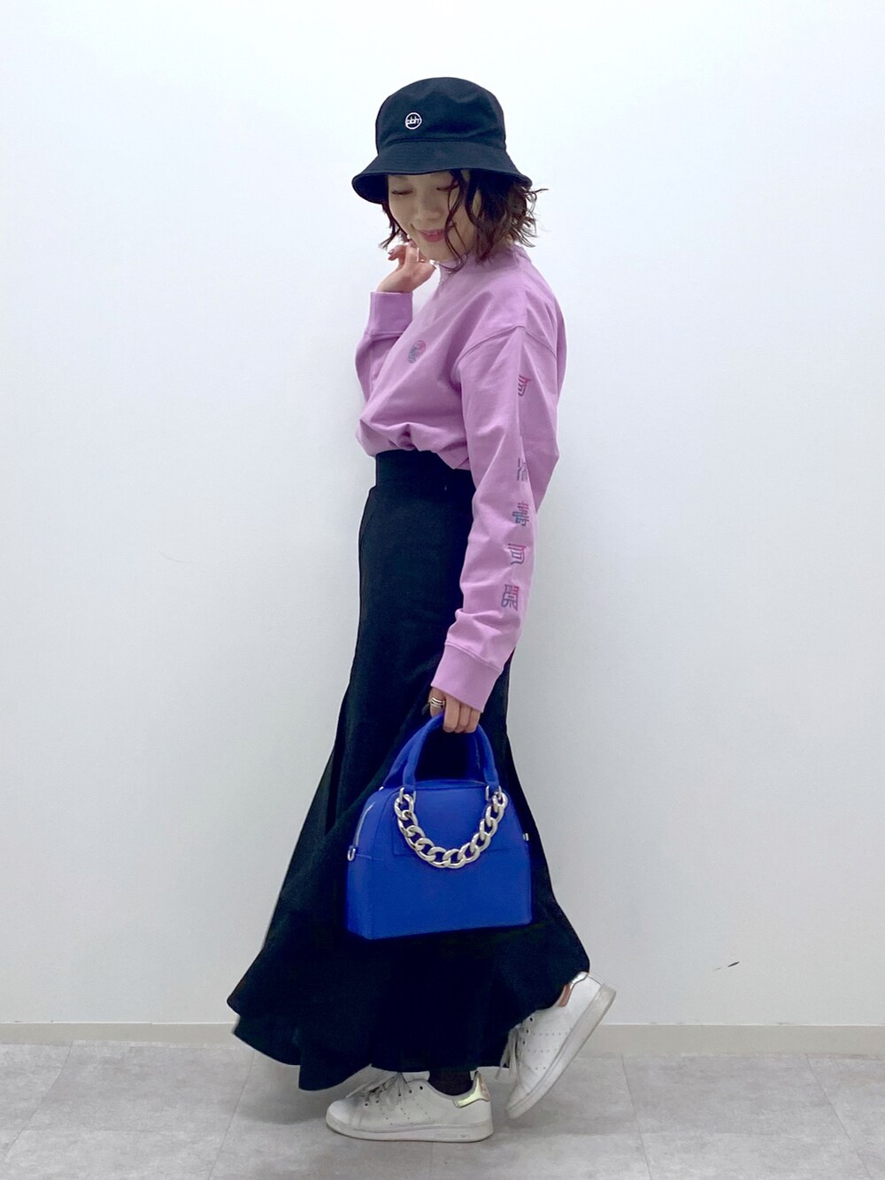 ピンク系のTシャツ/カットソー、ブラック系のスカート、ブルー系のショルダーバッグを着用したレディースの春コーディネートの4枚目の写真