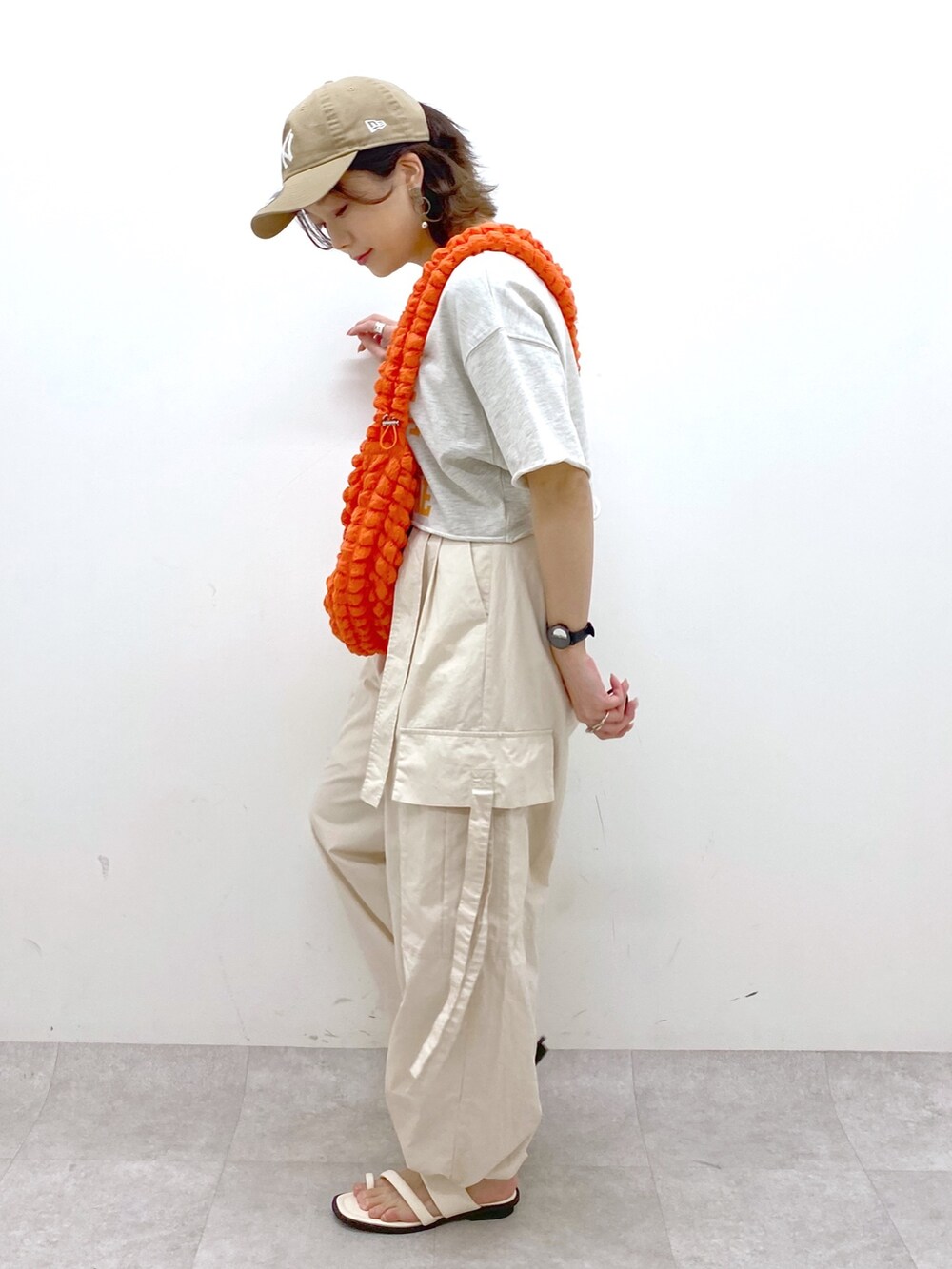 ホワイト系のカーゴパンツ、ホワイト系のサンダル、ベージュ系のTシャツ/カットソーを着用したレディースの春コーディネートの2枚目の写真