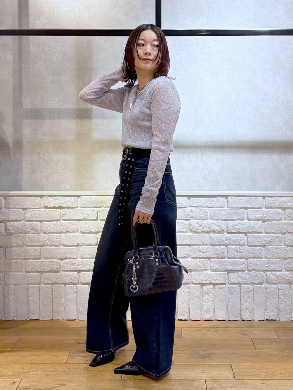 ブルー系のスラックス、ブルー系のハンドバッグ、ブルー系のタンクトップを着用したレディースの春コーディネートの7枚目の写真