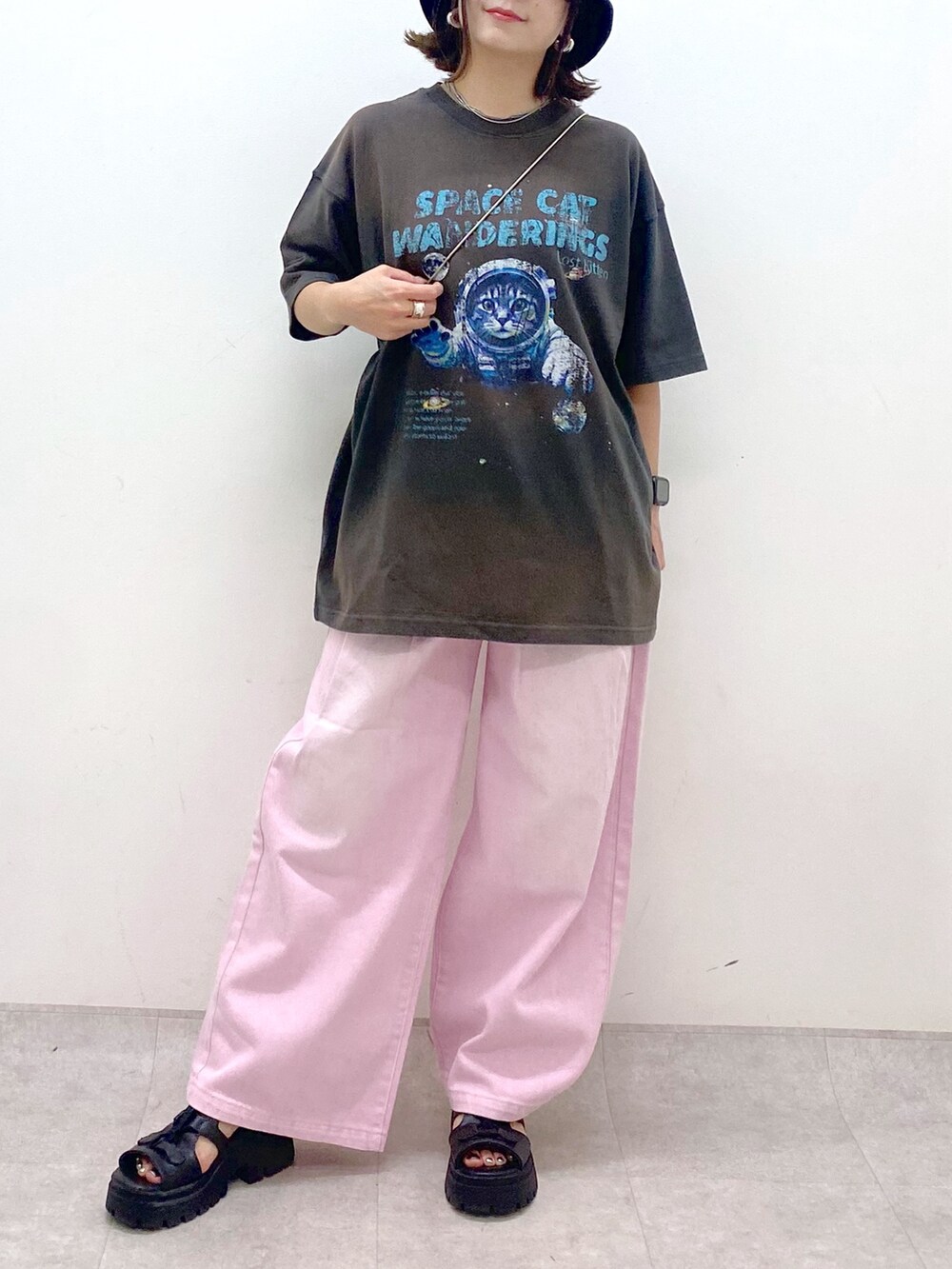 ピンク系のデニムパンツ、ブラック系のサンダル、ブラック系のショルダーバッグを着用したレディースの夏コーディネートの3枚目の写真