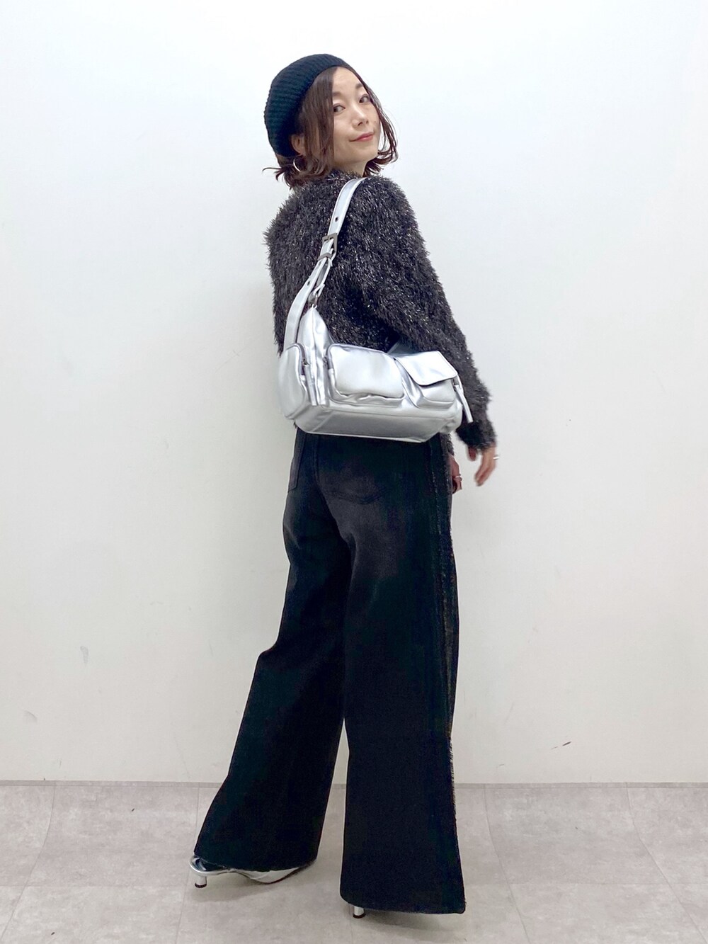 ブラック系のデニムパンツ、シルバー系のパンプス、シルバー系のショルダーバッグを着用したレディースの秋コーディネートの7枚目の写真