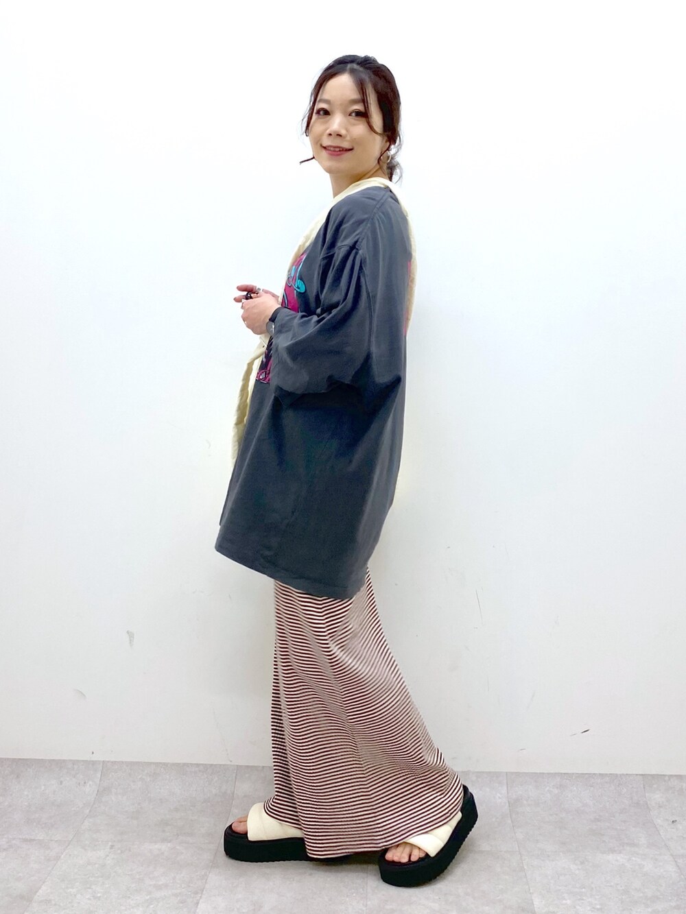 ブラウン系のワンピース、グレー系のTシャツ/カットソー、ホワイト系のショルダーバッグを着用したレディースの春コーディネートの3枚目の写真