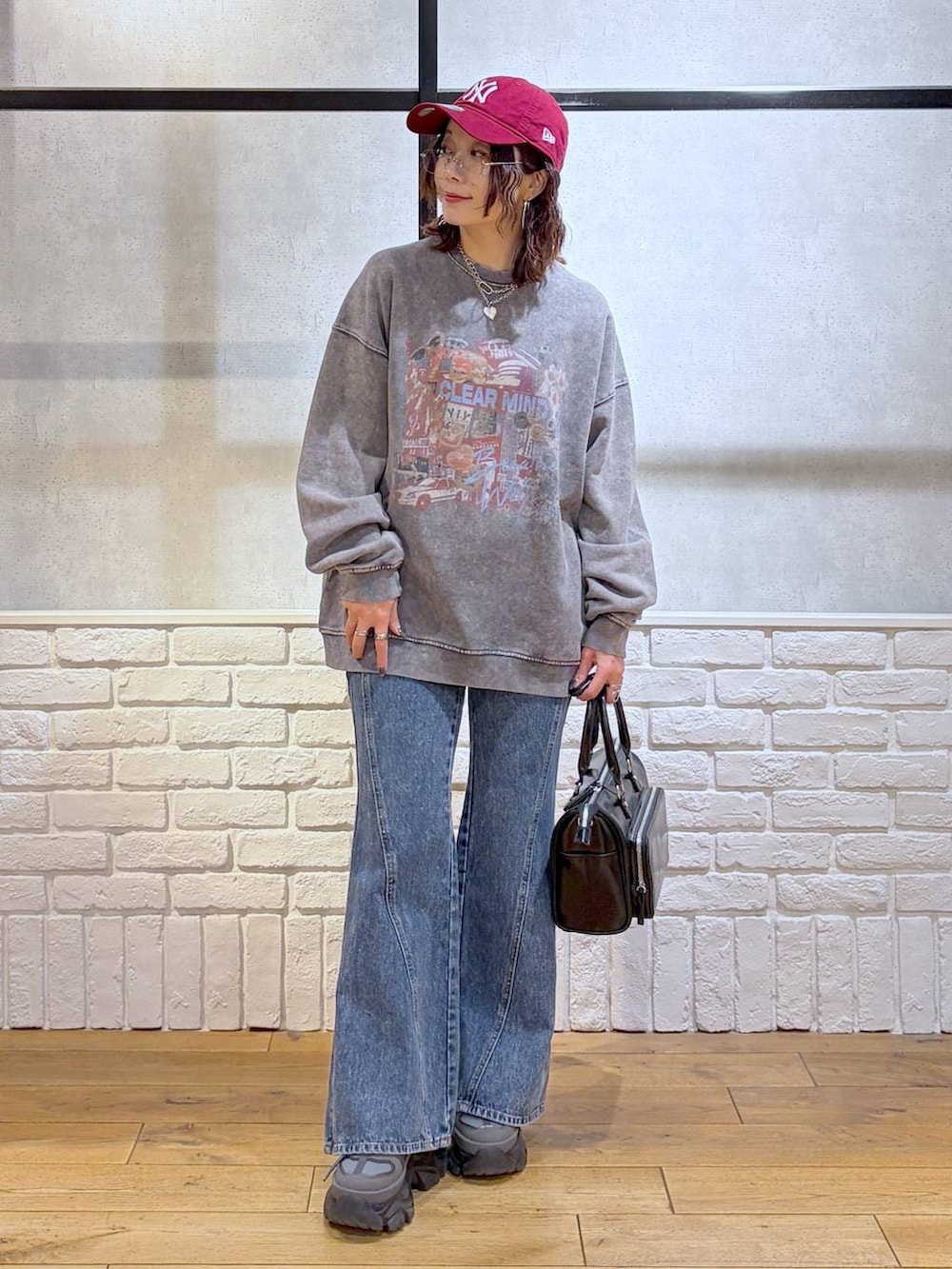 グレー系のスニーカー、ブルー系のデニムパンツ、ブラック系のショルダーバッグを着用したレディースの冬コーディネートの9枚目の写真