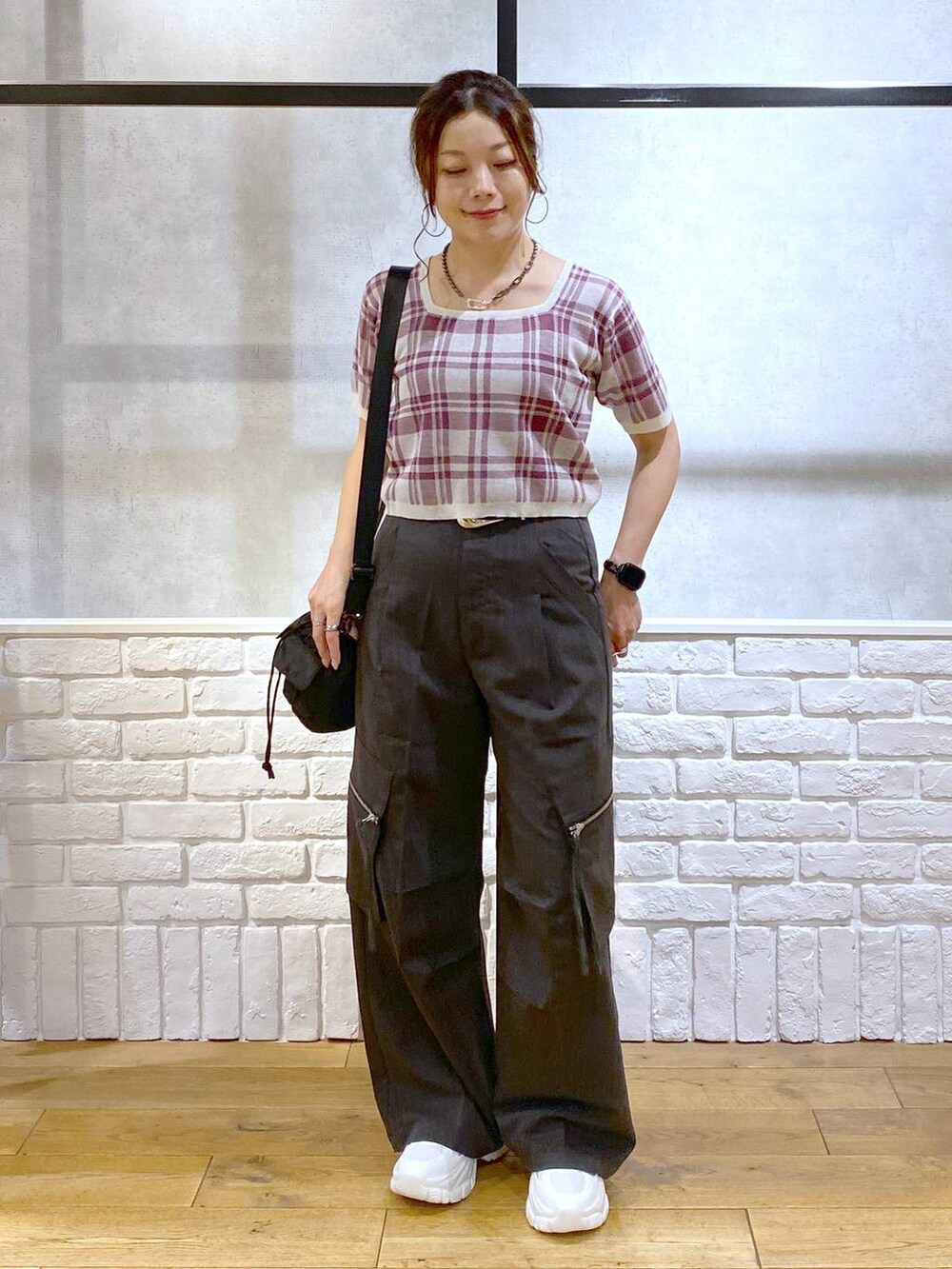グレー系のカーゴパンツ、ブラック系のショルダーバッグ、ホワイト系のスニーカーを着用したレディースの夏コーディネートの8枚目の写真