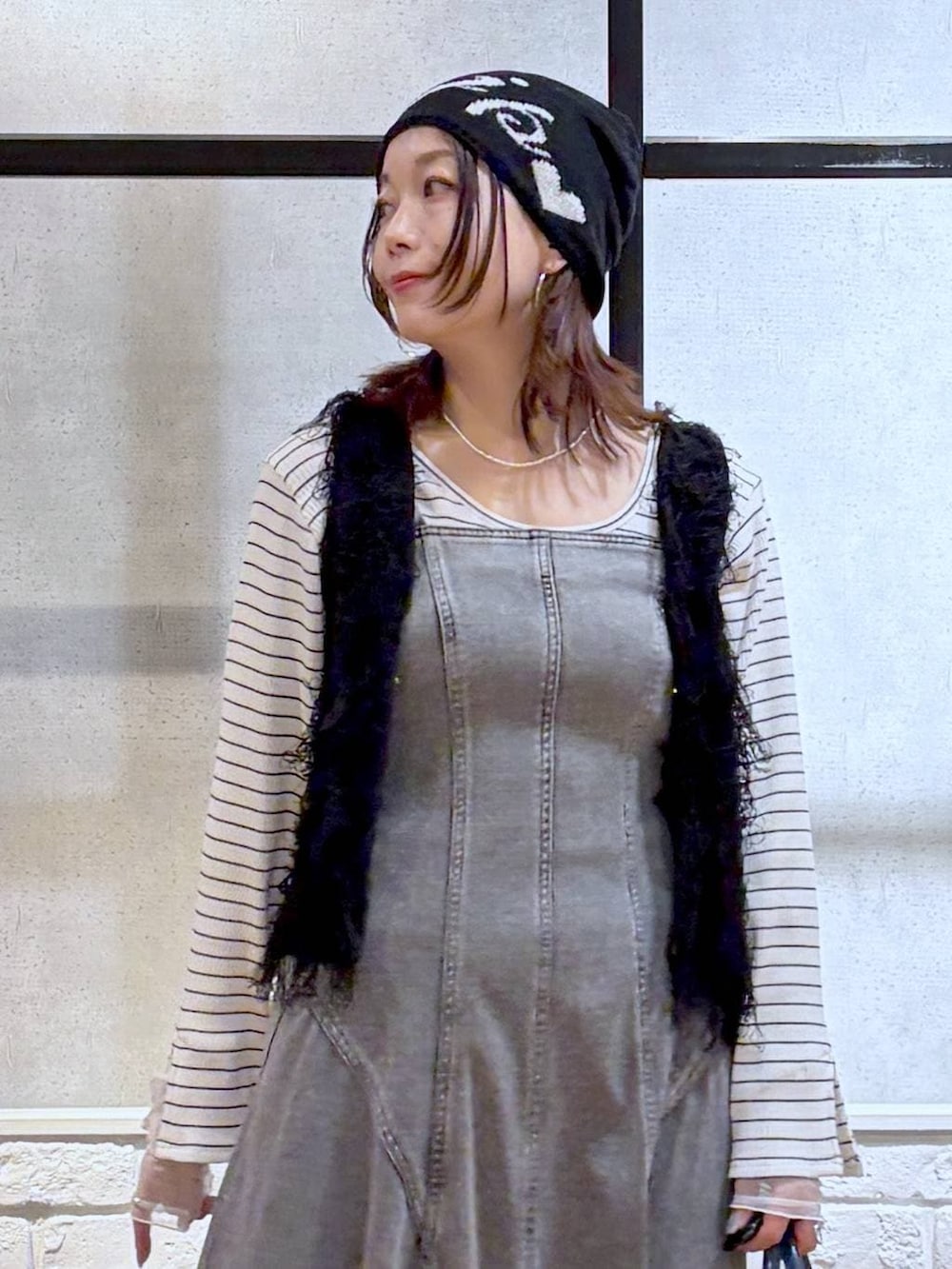 ブラック系のスニーカー、ブラック系のワンピース、ブルー系のショルダーバッグを着用したレディースの冬コーディネートの2枚目の写真