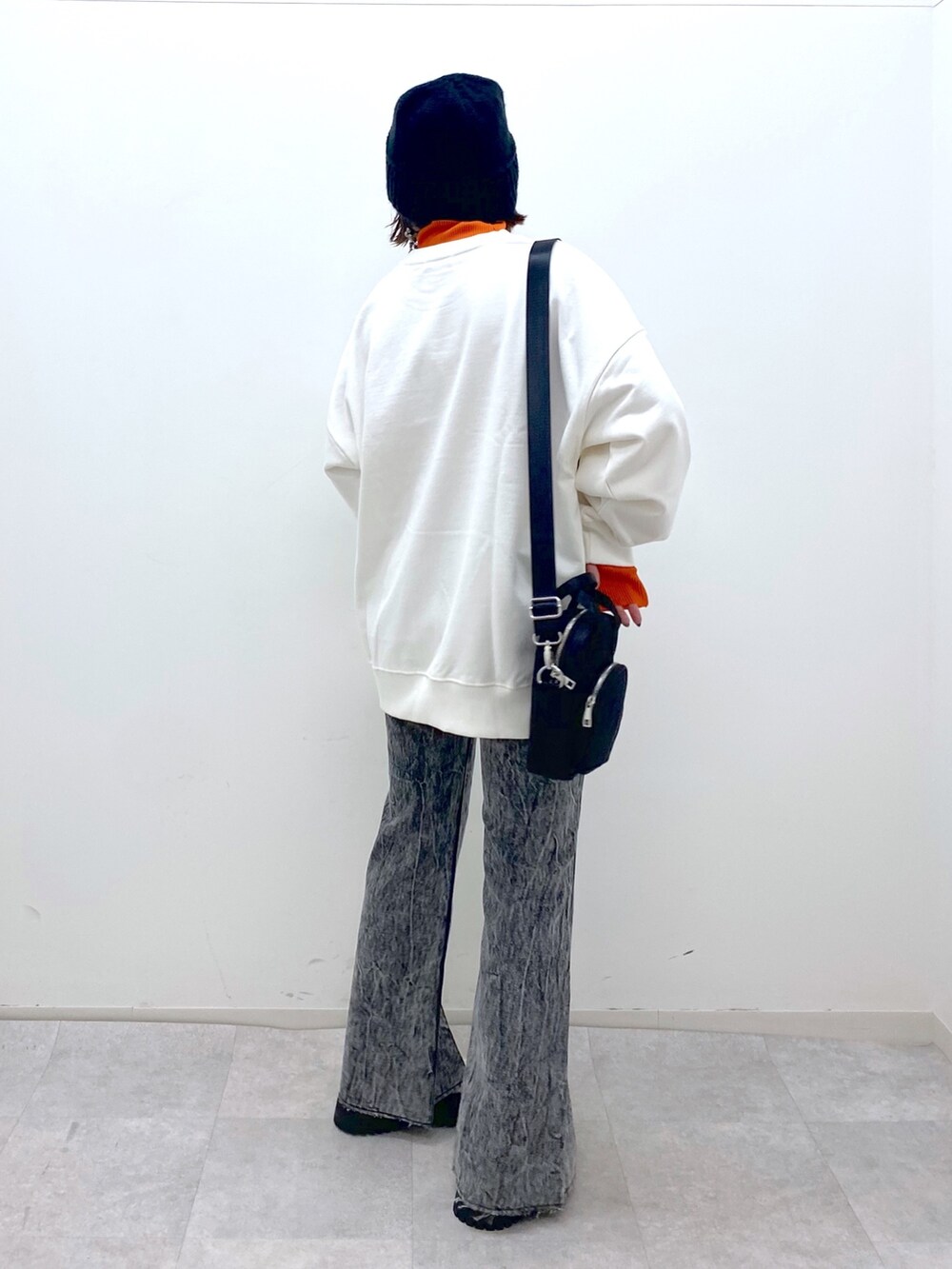 ホワイト系のトップス、オレンジ系のトップス、ブラック系のショルダーバッグを着用したレディースの秋コーディネートの4枚目の写真